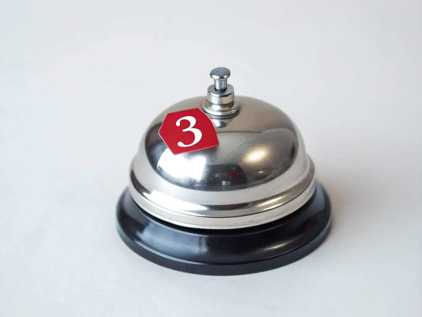 A focused image of a notification bell icon with a glowing emerald accent, set against a near-black background, representing real-time updates and alerts.